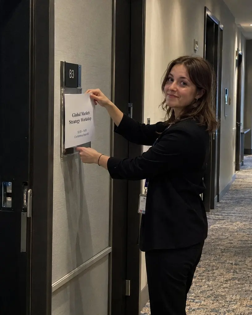 Hostess tauscht im Flur eines Tagungshotels das Raumschild für den nächsten Workshop aus – Event-Begleitservice in Berlin