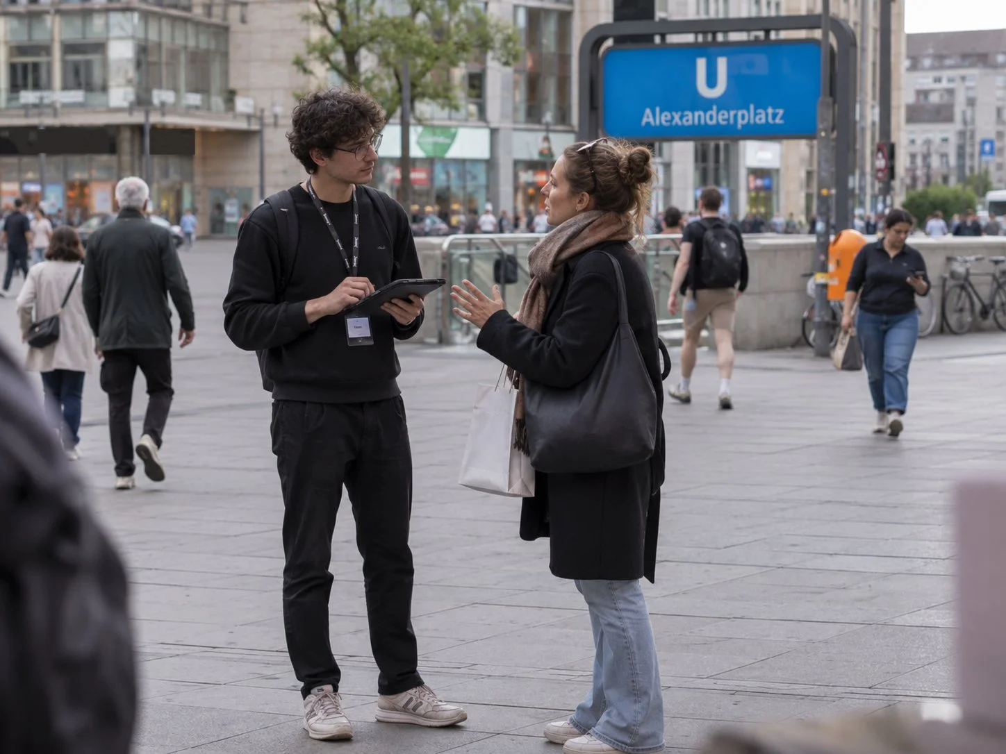 Interviewer mit Tablet befragt eine Passantin am Alexanderplatz