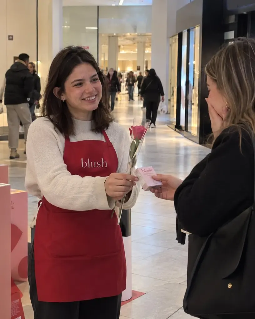 Promoter hands a customer a product sample in a shopping centre