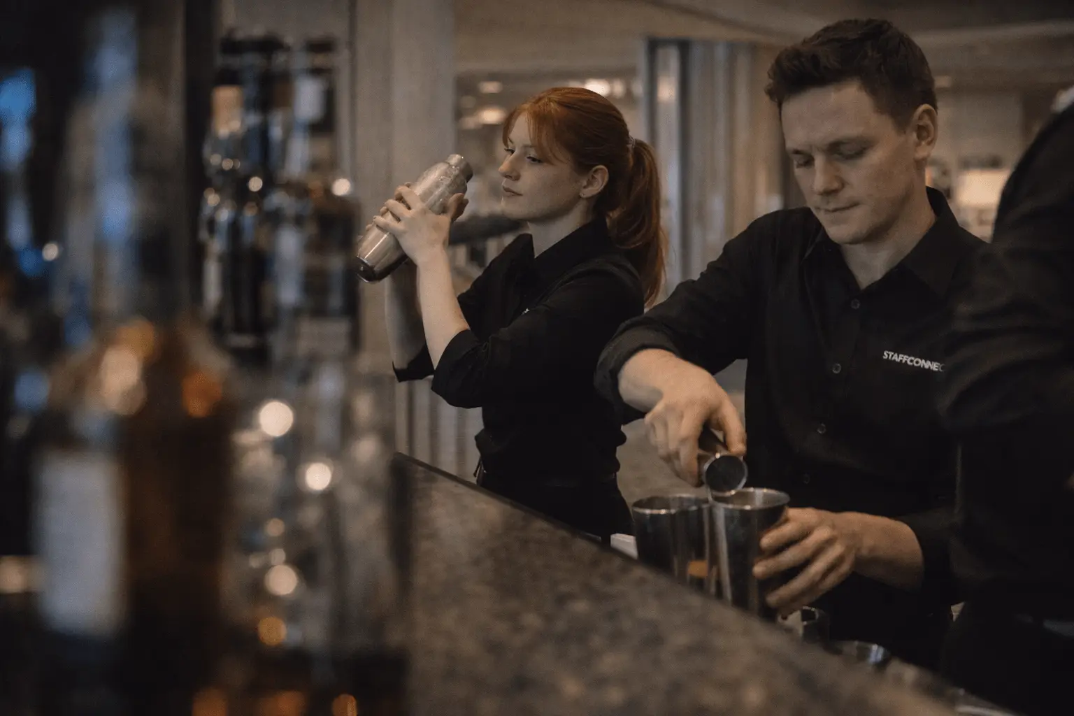 Zwei Barkräfte mixen Cocktails hinter der Eventbar